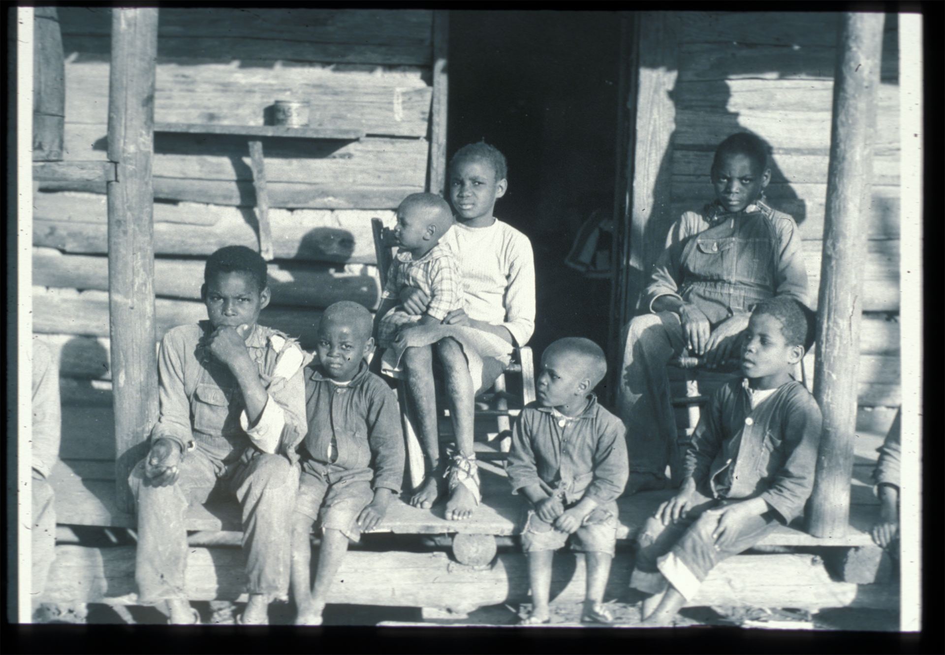 Historic photo of black family on cabin porch